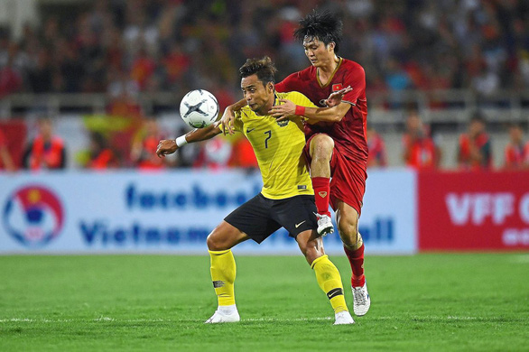  Vietnam's Nguyen Tuan Anh (R) fights for the ball with Malaysia's Mohamad Aidil Zafuan (L) during the Qatar 2022 World Cup qualifying football match between Vietnam and Malaysia at the My Dinh stadium in Hanoi on October 10,2019