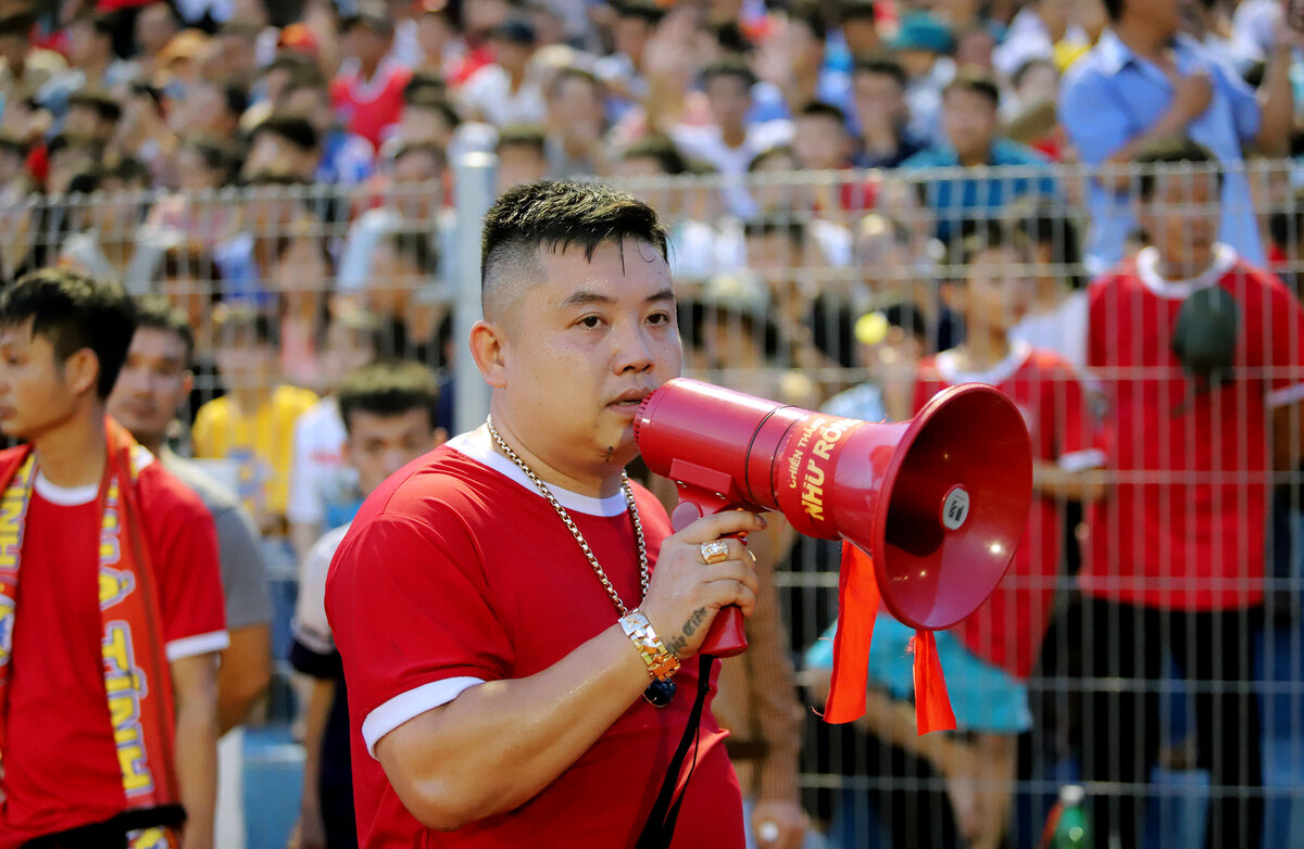 A stadium representative used a loudspeaker to address fans, asking them to return to their seats, but his words fell on deaf ears.