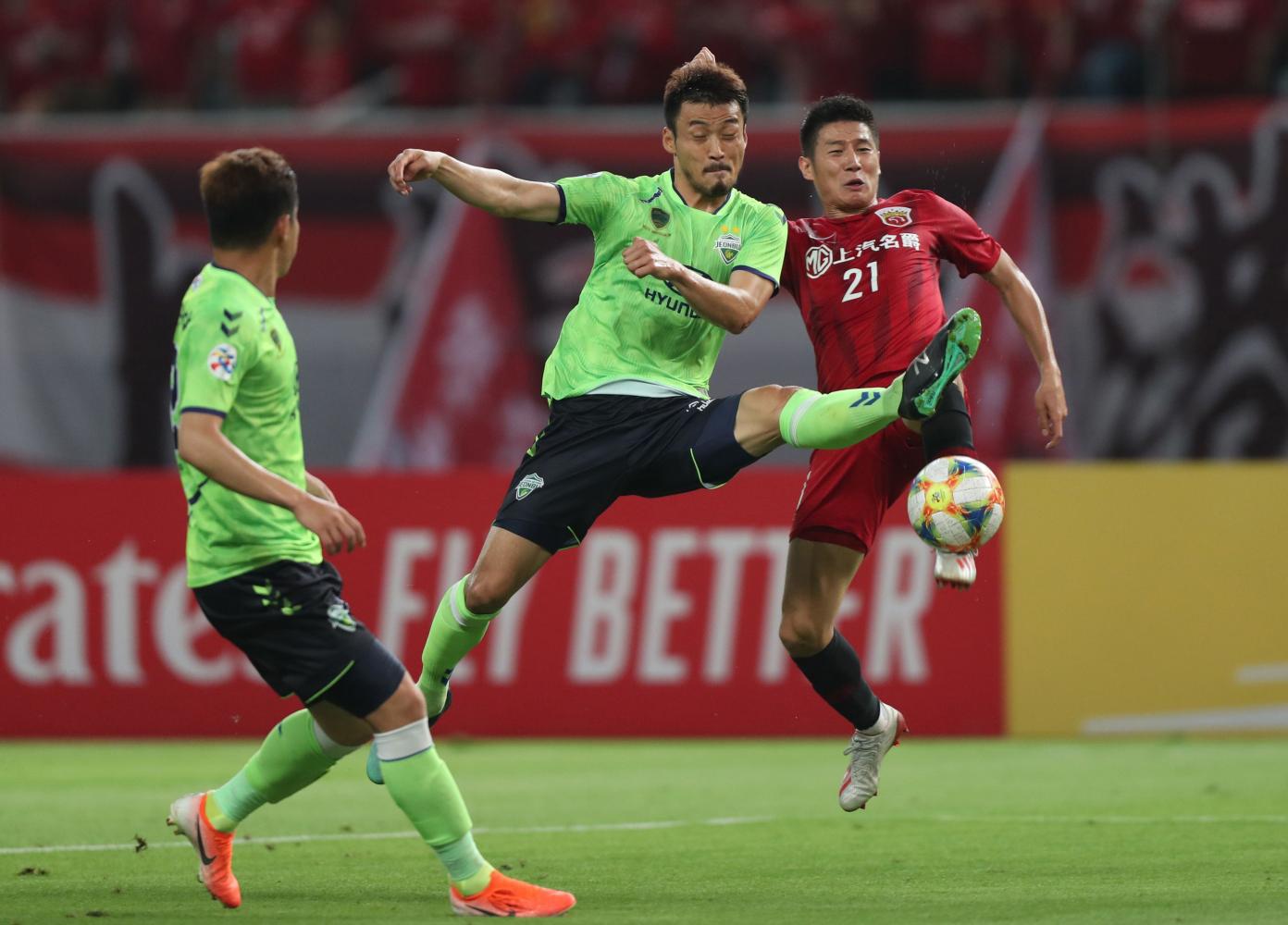Players from Jeonbuk Hyundai and Shanghai SIPG take part in an AFC Champions League game.  